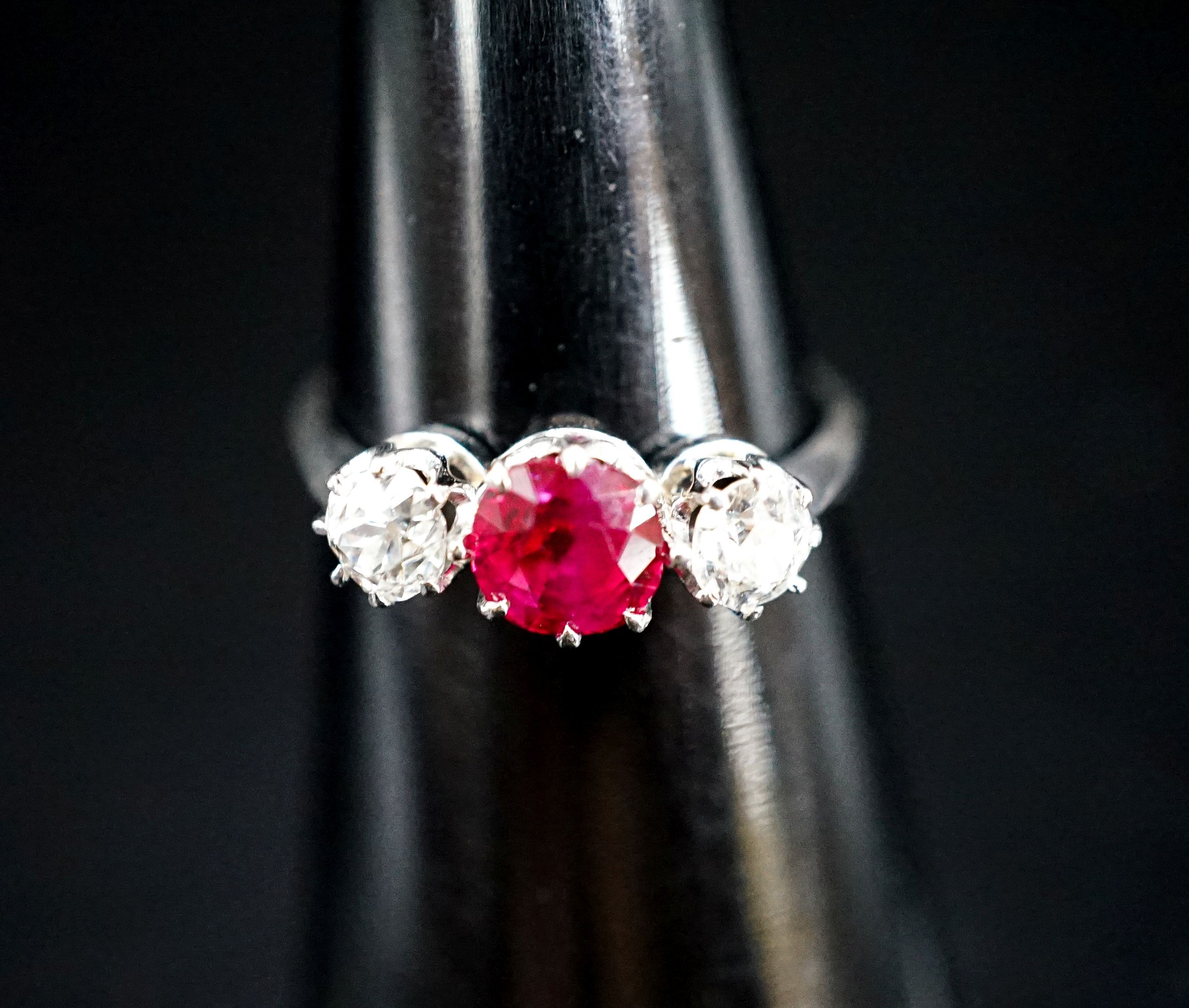 A white metal single stone ruby and two stone diamond ring, size L/M, gross weight 3 grams.